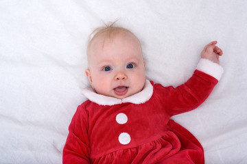 Portrait of cute little baby in a santa costume. Lying on white background. Christmas concept