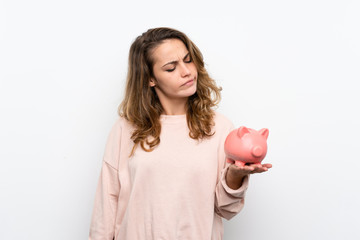 Young blonde woman holding a big piggybank