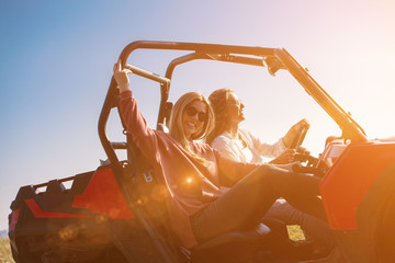 two young women driving a off road buggy car © .shock