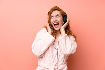 Redhead woman in dressing gown listening music
