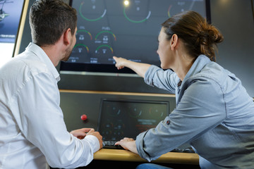 man and woman using screen of a machine