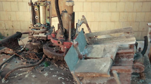 many old scrap, faulty, rusted mechanism, old machine from the factory, gears, with buttons on which lie a lot of rubber belts, slow motion, close up