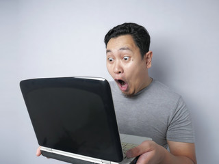 Funny Asian man shocked when Looking at His Laptop