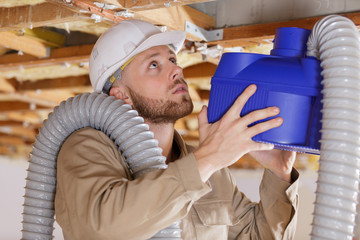 young male contractor installing an air conditioning unit