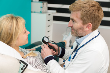 doctor measuring arterial blood pressure woman patient