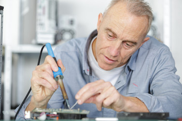 mature repairman working in technical support fixing computer laptop tr