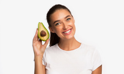 Smiling Woman Standing Holding Avocado, Studio Shot