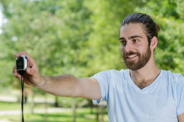 man holding forwards a stopwatch while training outdoors