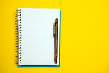 the white open notepad isolated on the yellow background