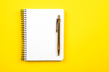 the white open notepad isolated on the yellow background