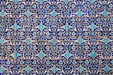 Maiolica style tin-glazed pottery tiled wall in ancient Khiva mosque in Uzbekistan. Abstract art background.