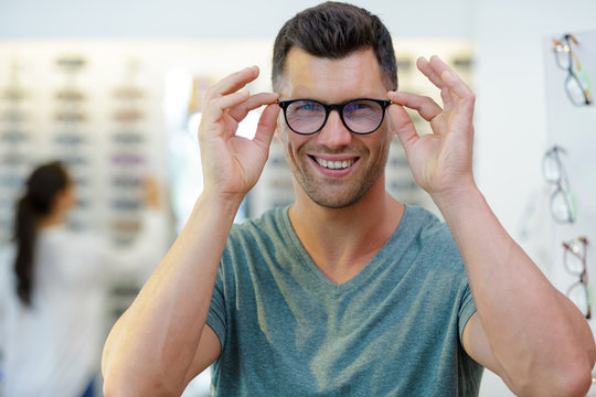 smiling man wearing eyeglasses in optical shop