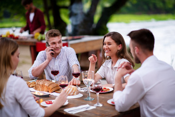 happy friends having picnic french dinner party outdoor