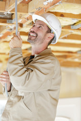 construction worker fixing cable in the ceiling