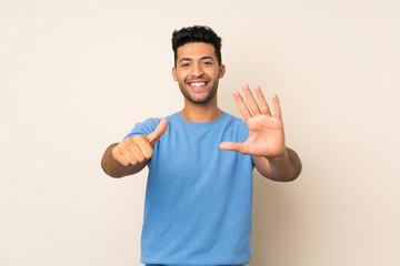 Young handsome man over isolated background counting six with fingers