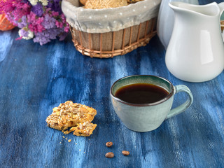 Porcelain cup with black coffee and shortbread.Are worth on backdrop of cold tones. 