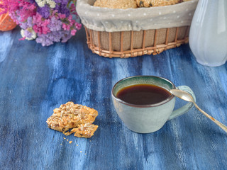 Porcelain cup with black coffee and shortbread.Are worth on backdrop of cold tones. 