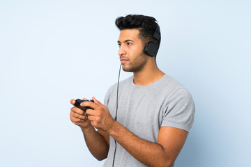 Young handsome man over isolated background playing at videogames
