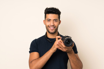 Young handsome man over isolated background with a professional camera