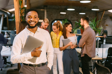 Happy businessman with laptop smiling to camera