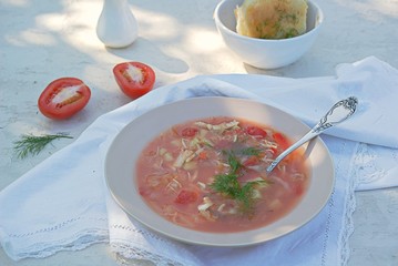 South borsch without beetroot, hot soup with tomatoes, cabbage and sweet red pepper. Served with unsweetened wheat buns with garlic and dill. Russian cuisine.