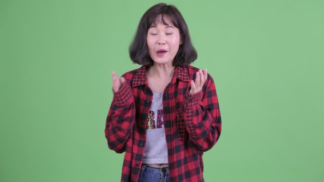 Happy Asian hipster woman talking and looking excited