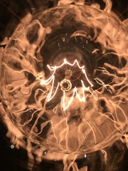 antique light bulb with zigzag filament and abstract reflections