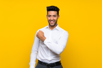 Young handsome man over isolated yellow background celebrating a victory