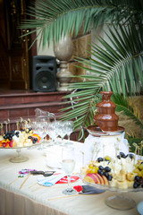 a small, beautiful girl in bright clothes,and in an orange hat, dancing near a Christmas tree, with a Christmas bouquet in her hand