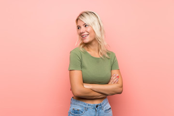 Young blonde woman over isolated pink background happy and smiling