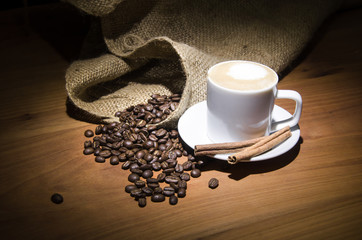 Coffee and coffee beans spotlight, on a wooden plate