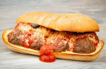 Close up of a submarine sandwich made of meatballs and tomato sauce
