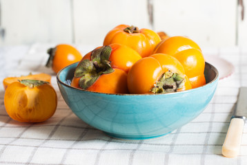 ripe fresh persimmons fruit, in a plate isolated on white background