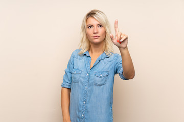 Young blonde woman over isolated background touching on transparent screen