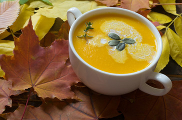 Pumpkin soup in a bowl on a wooden background