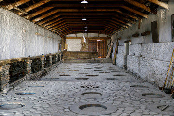 Interior of the traditional Georgian wine cellar with round holes in the floor for clay jugs for wine. Kveri