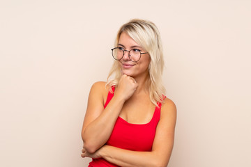 Young blonde woman over isolated background with glasses