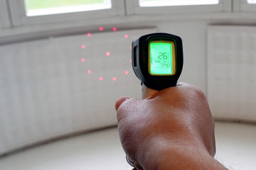 Measuring temperature with infrared laser thermometer from heating radiator.