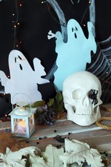 Skull, mystical decor, illumination, decorative lantern, autumn leaves on a wooden table, interior for Halloween, October