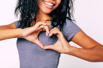 Love you. Close-up photo of African American woman palms, showing a hand heart to the camera.