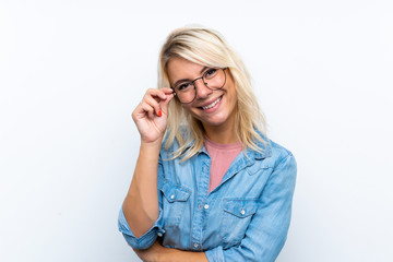 Young blonde woman over isolated white background with glasses and happy