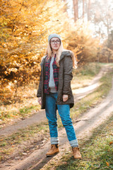 Obraz premium Hiking and travel along in the forest. Concept of trekking, adventure and seasonal vacation. Young woman walking in woods.
