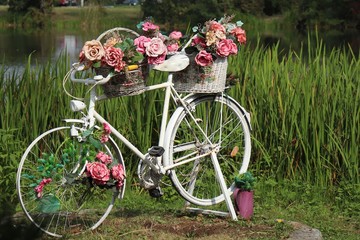 Fototapeta na wymiar street decor, a white bicycle with baskets of flowers on it