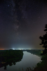 Stars of the Milky Way galaxy in the night sky over the river. Photographed with a long exposure.