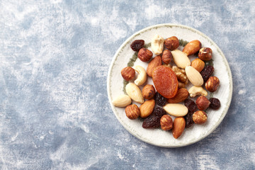 Nuts, raisins and apricots on rustic wooden background. Concept for healthy snack. Top view. Copy space. 