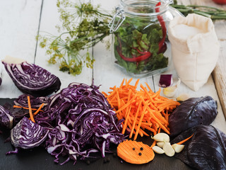 Harvesting vegetables. Sliced cabbage, carrot, garlic on a black board. Preparation for fermentation. Natural, organic food. Harvesting for the winter. Close-up. Autumn.