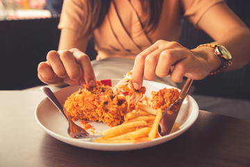 Close-up Fried chicken,freshfast on plate with fried chicken blur background,Woman eating fried chicken,Hungry,diet,Fat food,healthy food