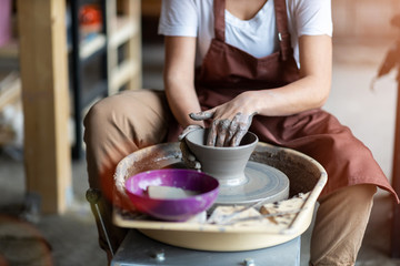 Fototapeta na wymiar Woman making ceramic work with potter's wheel