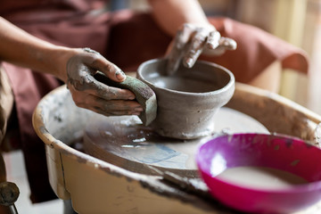Woman making ceramic work with potter's wheel