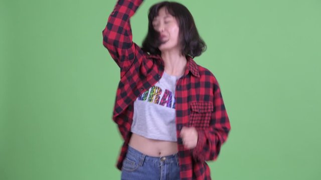 Happy Asian hipster woman dancing